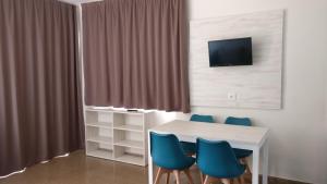 a dining room with a table and blue chairs at Aparthotel Las Mariposas in Lloret de Mar