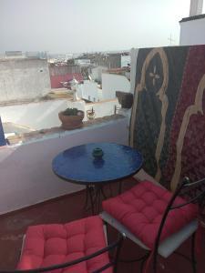 una mesa, 2 sillas y una mesa en el balcón en Dar Sam - Pacha Room, en Rabat