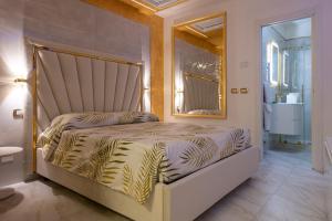 una camera da letto con un letto e un grande specchio di FASHION APARTMENT GOLD Bologna a Bologna