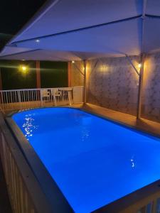 una piscina con iluminación azul en el techo en Villa Ar Rayis Beach, en Rayyis