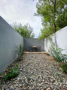 d'une terrasse avec une table et des chaises à côté d'un mur. dans l'établissement Penguins Flats 5, à Ushuaia