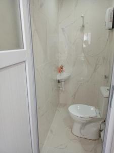 a white bathroom with a toilet and a sink at Ava suite in Istanbul