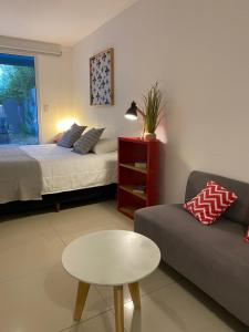 sala de estar con cama, mesa y sofá en Penguins Flats 5 en Ushuaia