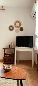 ein Wohnzimmer mit einem Flachbild-TV und einem Tisch in der Unterkunft Nona Ružica in Vis
