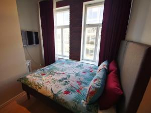 - un lit dans une chambre avec 2 fenêtres dans l'établissement Rotermanni Mere Apartment, à Tallinn