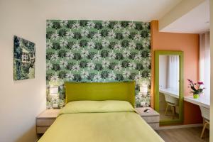 ein Schlafzimmer mit einem Bett mit grünem Kopfteil in der Unterkunft Petra Luxury Sorrento b&b in Sorrent