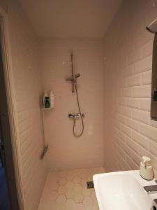 La salle de bains est pourvue d'une douche et d'un lavabo. dans l'établissement Rotermanni Mere Apartment, à Tallinn