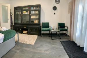 a bedroom with a tv and two chairs and a table at Dimora Apartman in Debrecen