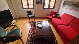 ein Wohnzimmer mit einem roten Sofa und einem Couchtisch in der Unterkunft Selestat entre Colmar et Strasbourg in Sélestat
