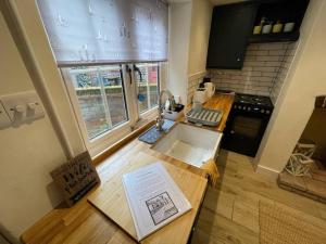 een keuken met een aanrecht met een wastafel en een raam bij Haven Cottage, Cromer in Cromer