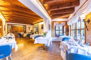 a dining room with white tables and blue chairs at Hotel Käppelehof in Lauterbach