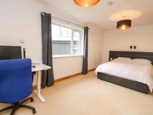 a bedroom with a bed and a desk and a window at Mullingar in Pitlochry