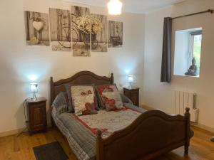 een slaapkamer met een bed met 2 nachtkastjes en 2 lampen bij L'Escapade de JOS gite équestre in Pont-de-Salars