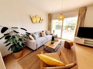 een woonkamer met een bank en een tv bij PtBja a estrenar GranTerraza Piscinas Altaona Golf in Murcia