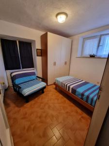 pokój z dwoma łóżkami i ławką w środku w obiekcie CASA GAIA - Limoncello - parcheggio privato incluso w mieście Levanto