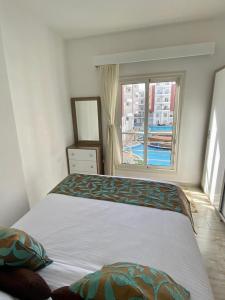 a bedroom with a large bed with a window at Elegant and Welcoming one bedroom apartment in Hurghada