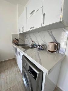 a kitchen with a sink and a washing machine at Elegant and Welcoming one bedroom apartment in Hurghada