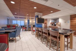 a restaurant with tables and chairs and a flat screen tv at Holiday Inn Express Radcliff Fort Knox, an IHG Hotel in Radcliff