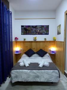 マラガにあるEncantador bajo en Málagaのベッドルーム1室(大型ベッド1台、ナイトスタンド2台付)