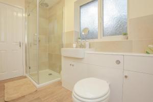 uma casa de banho com um WC, um lavatório e um chuveiro em Modern Cotswold Home em Witney