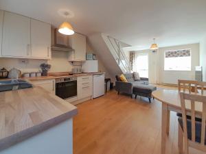a kitchen and living room with a table and a dining room at Modern Cotswold Home in Witney