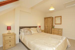 a bedroom with a large bed and a wooden cabinet at Modern Cotswold Home in Witney