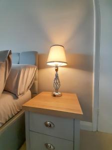 a lamp on a table next to a bed at New Marston Apartment in Oxford