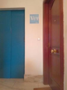 a hallway with two blue doors and a sign on a wall at A Bruxo Fonte.8 pzs,2 bañs .Full in Luarca