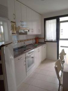 a white kitchen with a sink and a stove at A Bruxo Fonte.8 pzs,2 bañs .Full in Luarca