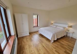 a bedroom with a bed and a wooden floor at 4 bedroom Holiday Home In Union Hall, West Cork in Union Hall