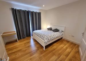 a bedroom with a bed with black curtains and wooden floors at 4 bedroom Holiday Home In Union Hall, West Cork in Union Hall