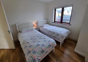 deux lits jumeaux dans une chambre avec fenêtre dans l'établissement 4 bedroom Holiday Home In Union Hall, West Cork, à Union Hall 7 autres photos