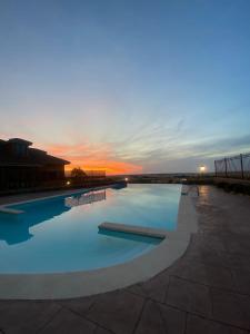 una gran piscina con puesta de sol en el fondo en Hotel El Rancho en Segovia