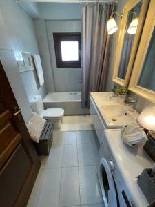 Un baño con bañera, inodoro y lavabo. en Siki House, en Sikí 33 fotos más