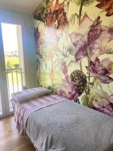 a bedroom with a flower mural on the wall at Casa Ariel in Lucca