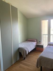 1 dormitorio con 2 camas individuales y balcón en Casa Ariel, en Lucca 26 fotos más