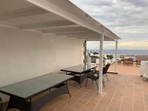 - deux tables et des chaises sur une terrasse donnant sur l'océan dans l'établissement The Tent, à Güime