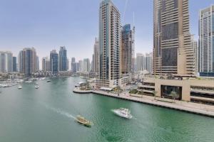un río con barcos en una ciudad con edificios altos en Cayan Tower, Dubai Marina - Charming One Bedroom, en Dubái