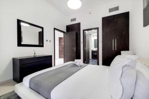 Un dormitorio con una gran cama blanca y un espejo. en Cayan Tower, Dubai Marina - Charming One Bedroom, en Dubái 9 fotos más