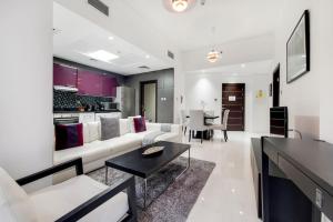 Una sala de estar con un sofá blanco y una mesa. en Cayan Tower, Dubai Marina - Charming One Bedroom, en Dubái