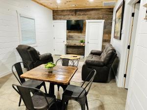 - un salon avec une table, des chaises et un canapé dans l'établissement Knotty Squirrel Cabins, à Mountain View
