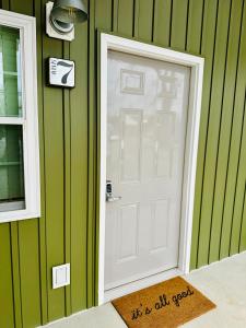 a white door in a green wall with a window at Knotty Squirrel Cabins in Mountain View