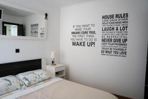 een slaapkamer met een bed met woorden op de muur bij Rovigno tesoro 1 in Rovinj