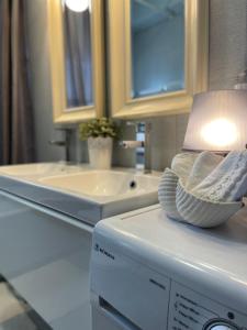 a bathroom with a sink and a lamp on a washing machine at Siki House in Sikí