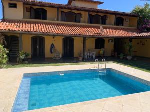 a swimming pool in front of a house at ALOHA LAGOON CABO FRIO in Cabo Frio