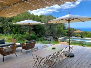 a patio with tables and chairs and umbrellas at Casa Altura in Coti-Chiavari