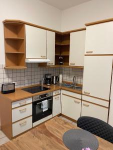 een keuken met witte kasten en een fornuis met oven bij Schöne Wohnung am Schlossgarten in Schwerin