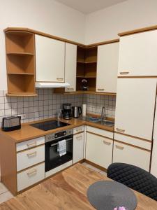 a kitchen with white cabinets and a stove top oven at Schöne Wohnung am Schlossgarten in Schwerin