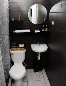 a bathroom with a white toilet and a sink at Habitación Deluxe Aire - Villa Valle Campo 