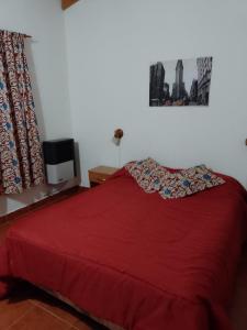 1 dormitorio con cama roja y manta roja en Luz de luna en Esquel